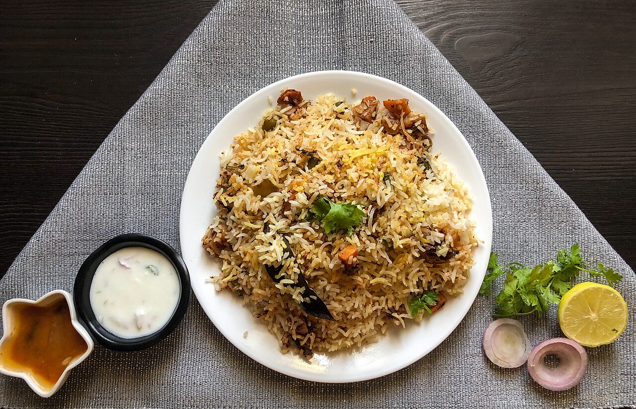 Hyderabadi dum biryani served with sides